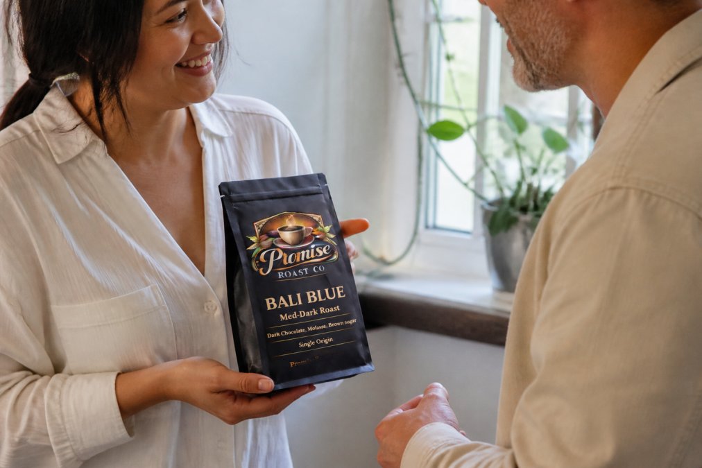 Hands holding a small bag of artisan-roasted coffee beans with a roast date label clearly visible, natural daylight from a nearby window illuminating the beans and label