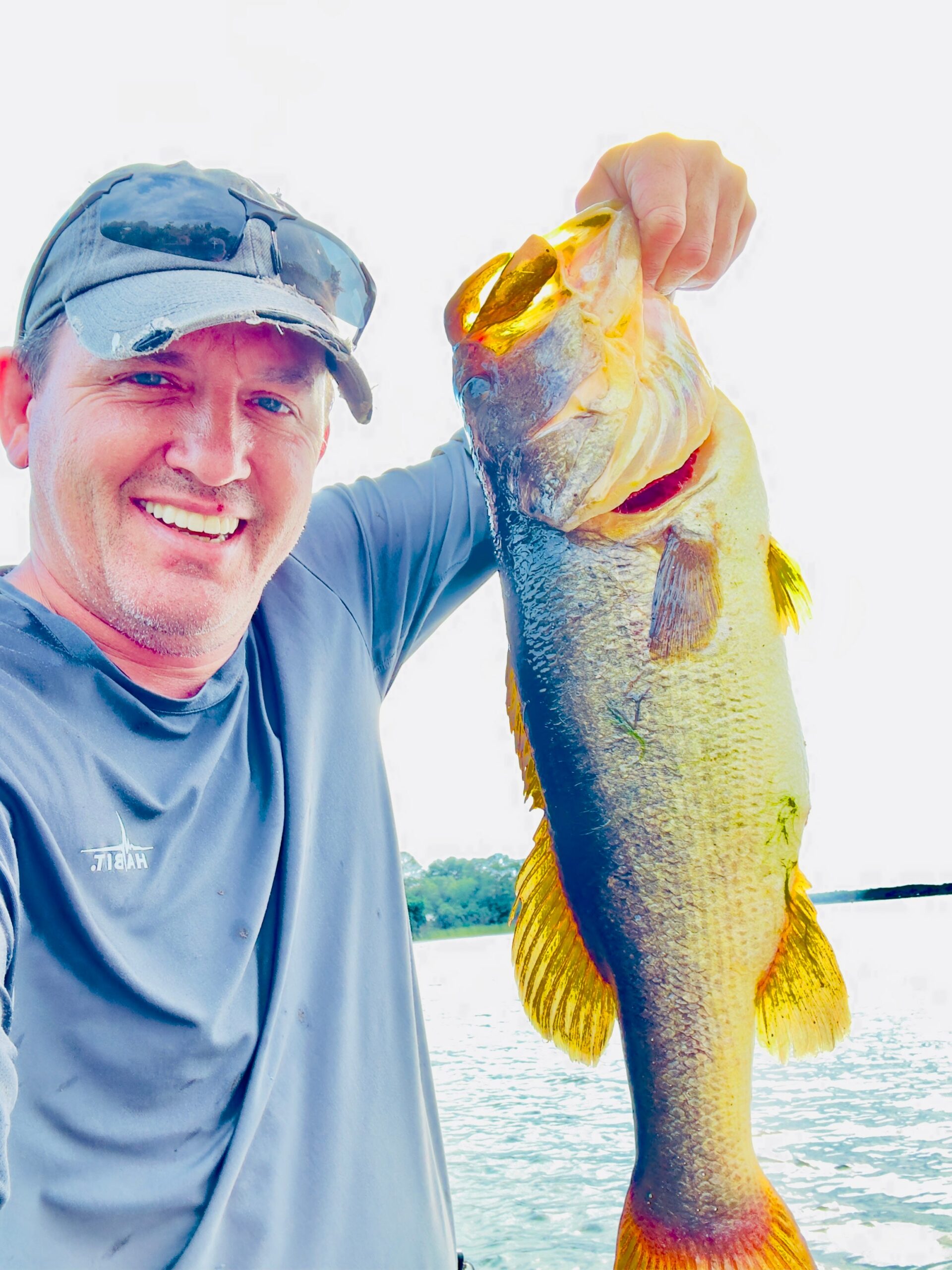 Donnie Moore, owner of Promise Roast Co., holding a largemouth bass while fishing in Florida